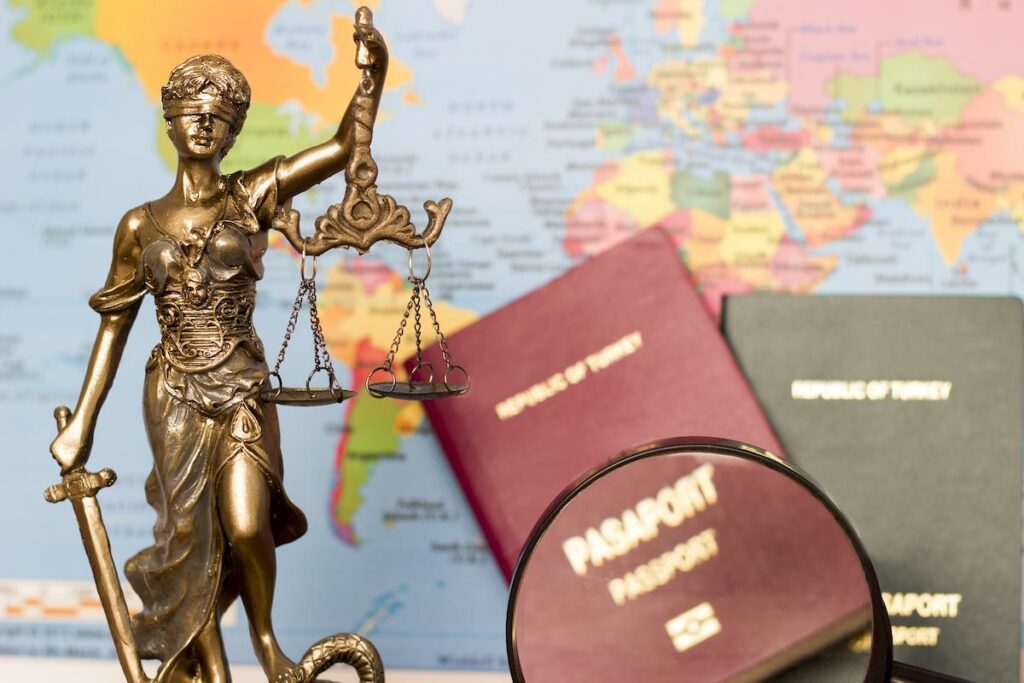 What Happens if You Commit a Crime in Another Country | Schaffer Kennedy Johnson Law concept, statue, magnifying glass, passport and world map.
