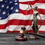 Exploring Common Defenses in Criminal Cases in Texas | Schaffer Kennedy Johnson US flag with a statue of justice, judge wooden hammer