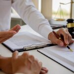 Sentencing Guidelines for White-Collar Crimes in Texas | Schaffer Kennedy Johnson Legal counsel presents to the client a signed contract with gavel and legal law or legal having team meeting at law firm in background
