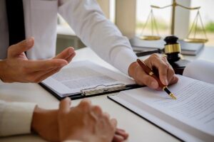 Legal counsel presents to the client a signed contract with gavel and legal law or legal having team meeting at law firm in background